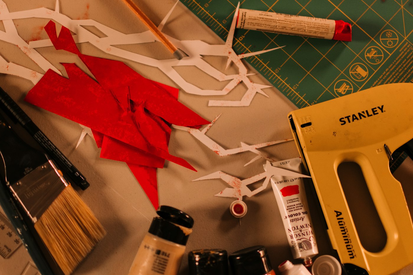 Real editorial photograph of craft scissors paper shapes and paint. Cover for Finishing Imperfect Projects