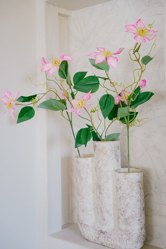 Vaaleanpunainen kärhön oksa silkkikukkana maljakossa