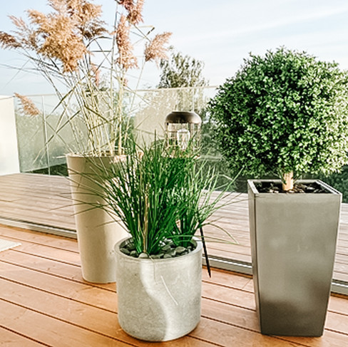 Moderni terassi tekokasveilla – suuret ruukut ja koristeheinät