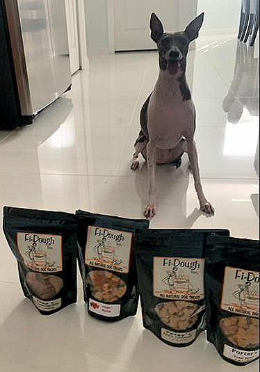 A dog enjoying Fi-Dough's organic biscuits!