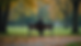 Eye-level view of a solitary person sitting quietly on a park bench, reflecting