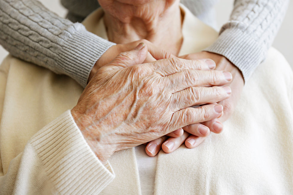 Mature female in elderly care facility gets help from hospital personnel nurse. Senior wom