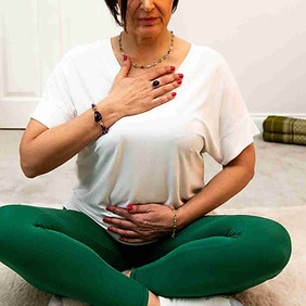 Jolene seated on a mat demonstrating conscious connected breathwork for nervous system regulation.