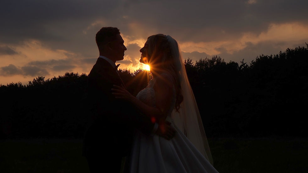 A Bride and Groom standing face to face in the sunset at Lillibrooke Manor wedding venue.