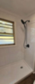 Modern residential remodeling of a white tiled shower.