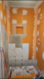 Residential bathroom shower remodeling with orange waterproof membrane.