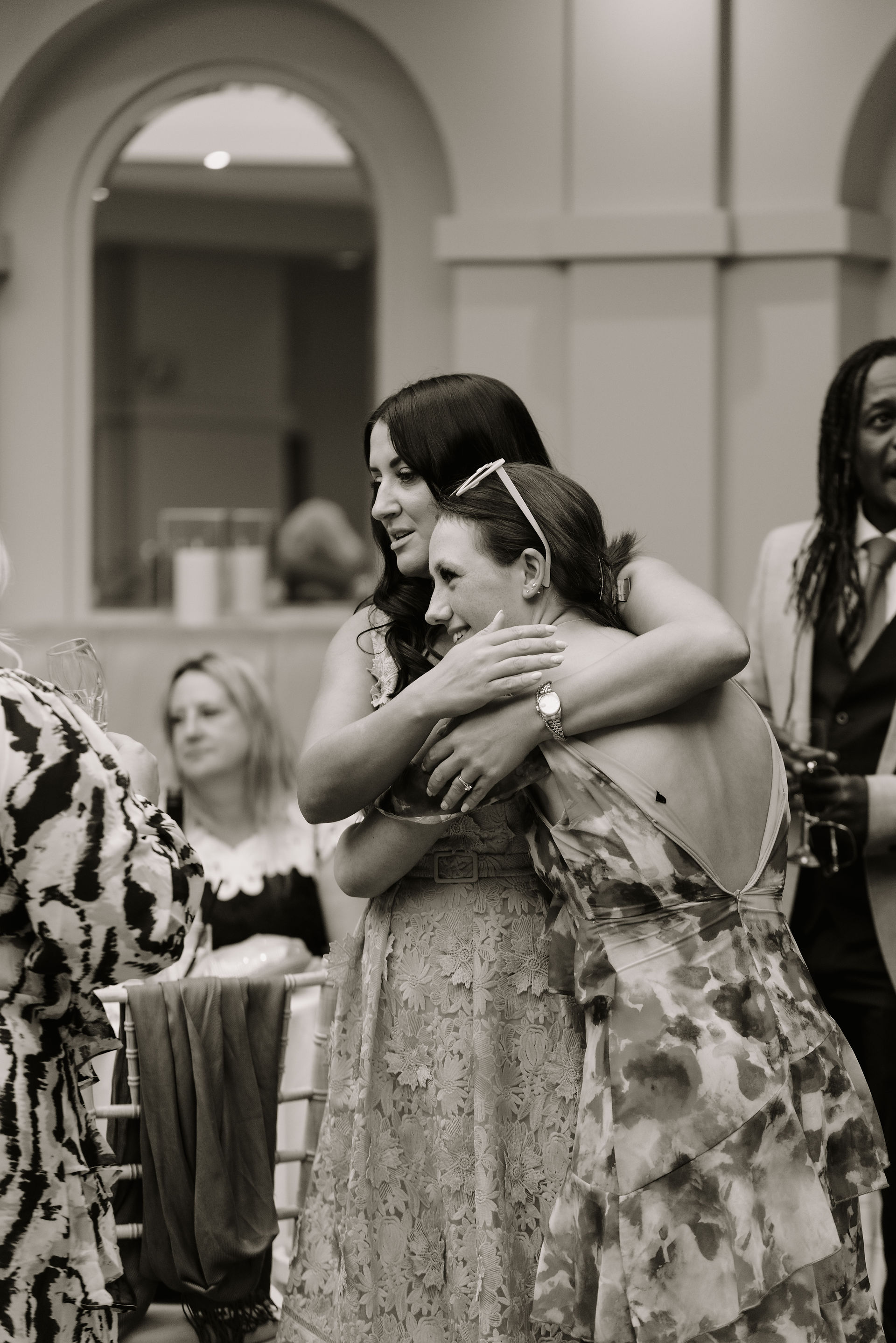 Emotional hug between guests, black and white candid from Kent wedding