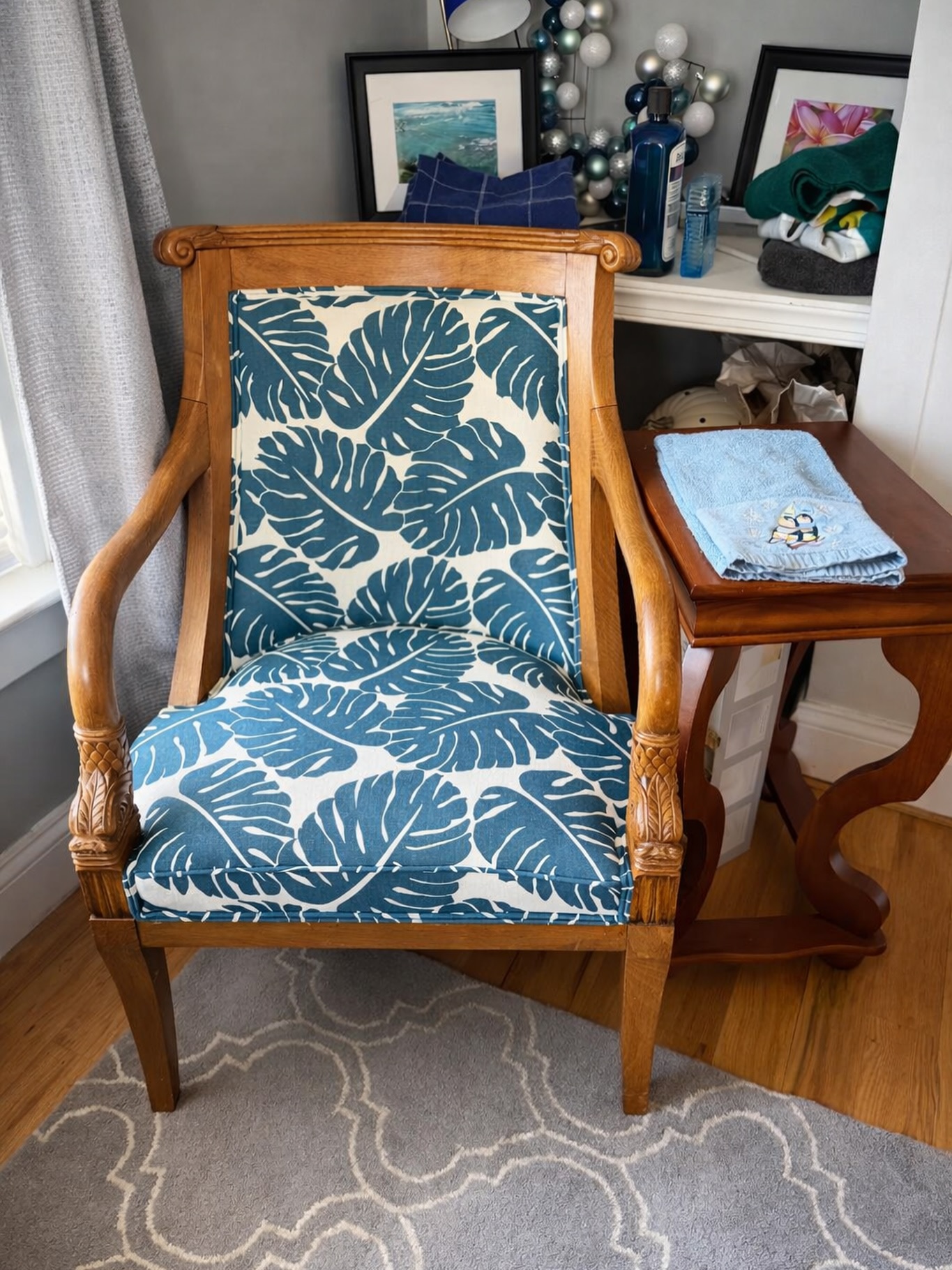 Accent chair professionally reupholstered with blue and green tropical patterned fabric in a custom upholstery project.
