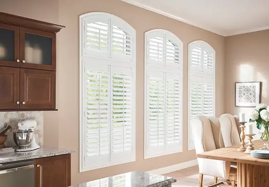 Arched and rectangular dining room windows in Annapolis with custom white Graber wood shutters.