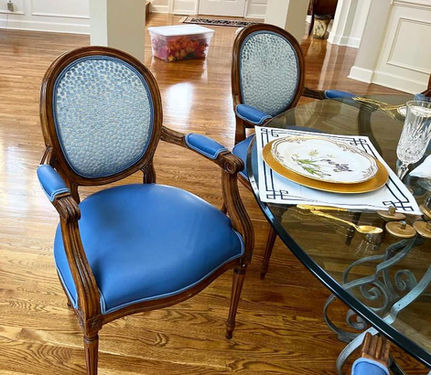 Pair of dining chairs with wood frames, blue leather seats, and patterned fabric backs, reupholstered by Mill End Shops.