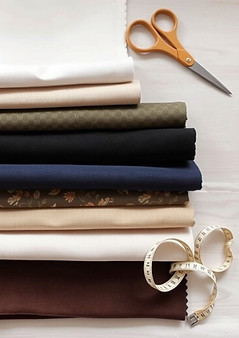 Multiple neatly arranged fabric swatches (linen, velvet, prints, neutrals)__Natural lighti