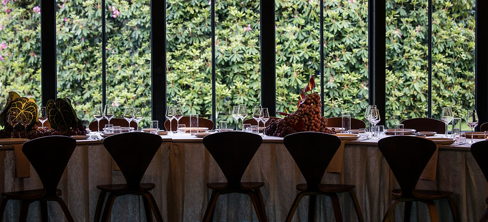 Sophisticated tablescape with designer chairs and floral centerpieces framed by floor-to-ceiling windows, styled by La Cinquième for a destination event.