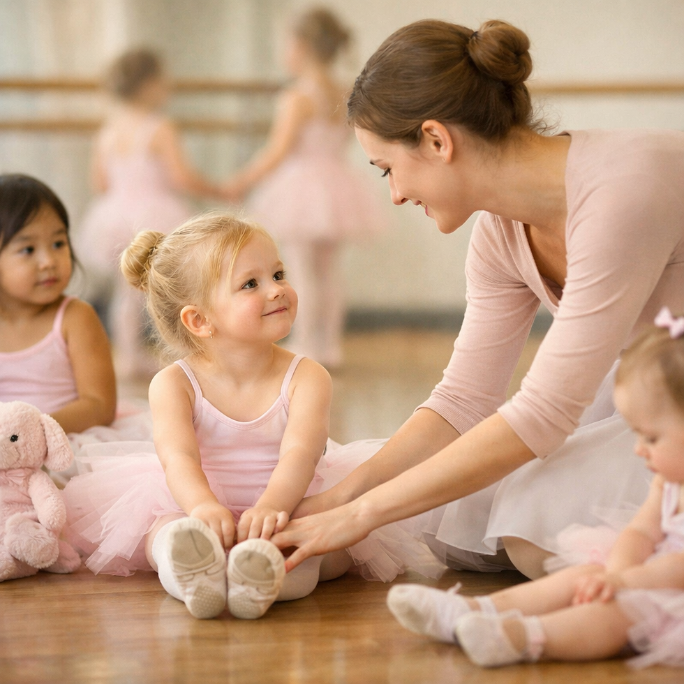 A ballet teacher gently helps a young child stretch during her first ballet class, surrounded by other toddlers in pink tutus at Little Starshine Ballet.