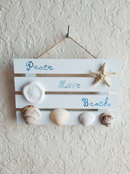 Peace, Love , beach - a 3x5 wood crate flat painted in white decorated with the words peace, love, beach with a sand dollar, starfish and 4 shells which is an ode to the love and peace you feel at the beach | peace | love | beach | beach decor | seashells | sand dollars | starfish