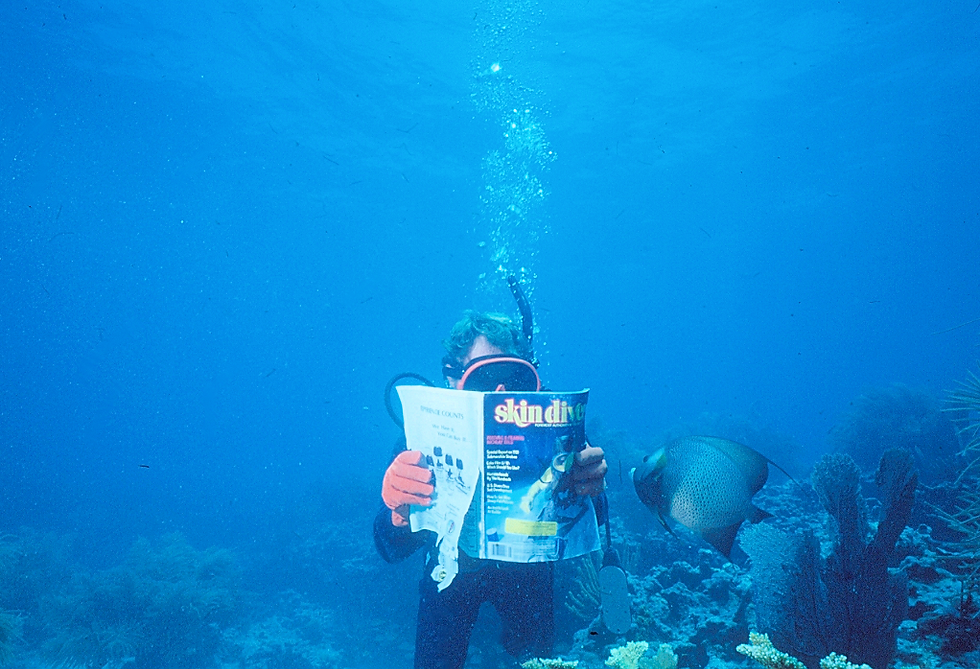 Skin Diver Magazine | Dad reading Skin Diver magazine with an interested French Angel Fish | underwater photography | underwater world | underwater life | angel fish | French angel fish | coral reef | reef life | salt life