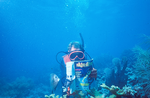 Skin Diver Magazine | my dad reading underwater again with his angelfish friend trying to read, too | underwater photography | underwater world | underwater life | angelfish | coral reef | reef life | salt life | skin diver magazine