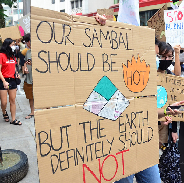 A person holding a banner that says
"Our sambal should be hot but the earth definitely should not"