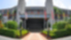 A building entrance with "Dewan Canselor Tun Abdul Razak" and flags. Lush green landscaping in front, under a bright blue sky. This is the hall from UKM.