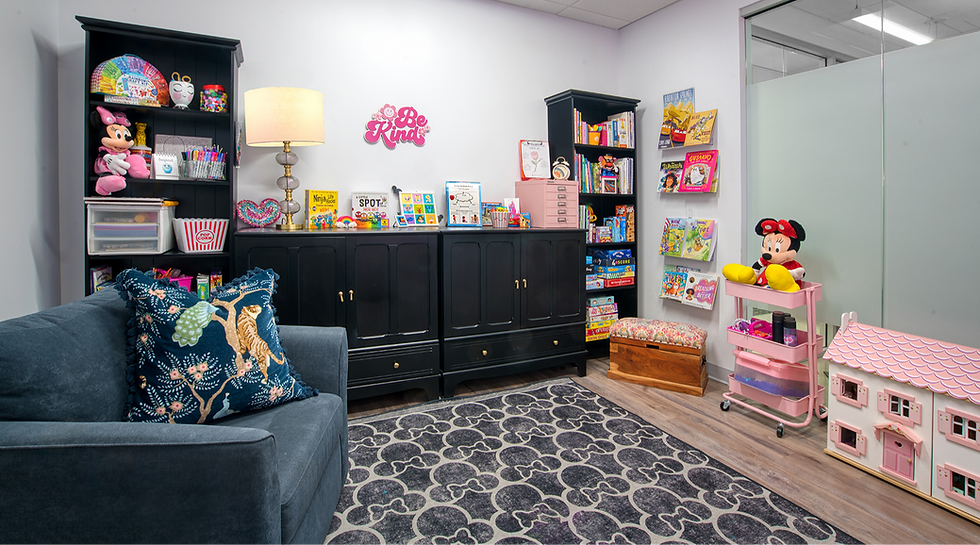 Eye-level view of a play therapy room with calming blue walls, organized shelves, and sensory toys neatly arranged