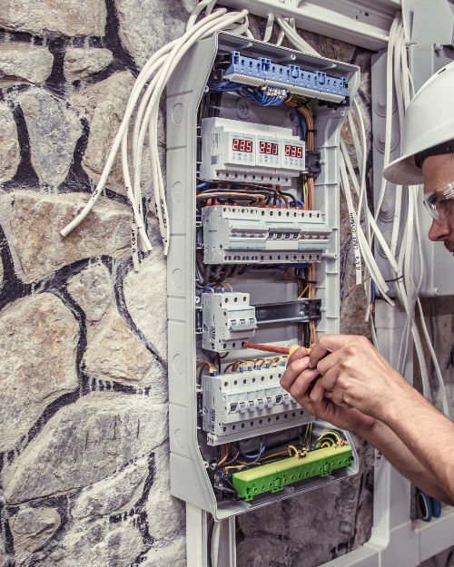 male-electrician-works-switchboard-with-electrical-connecting-cab.jpg