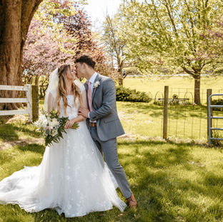 Wedding couple kissing for the wedding photographer to take their photo.
