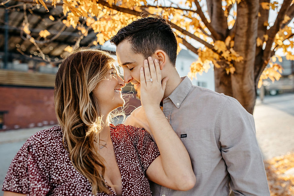 Engaged couple rubbing noses as the girl shows off her engagement ring.