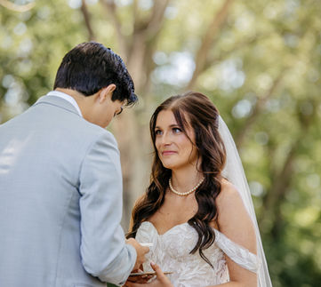Wedding couple reading their vows to each other on a bridge.
