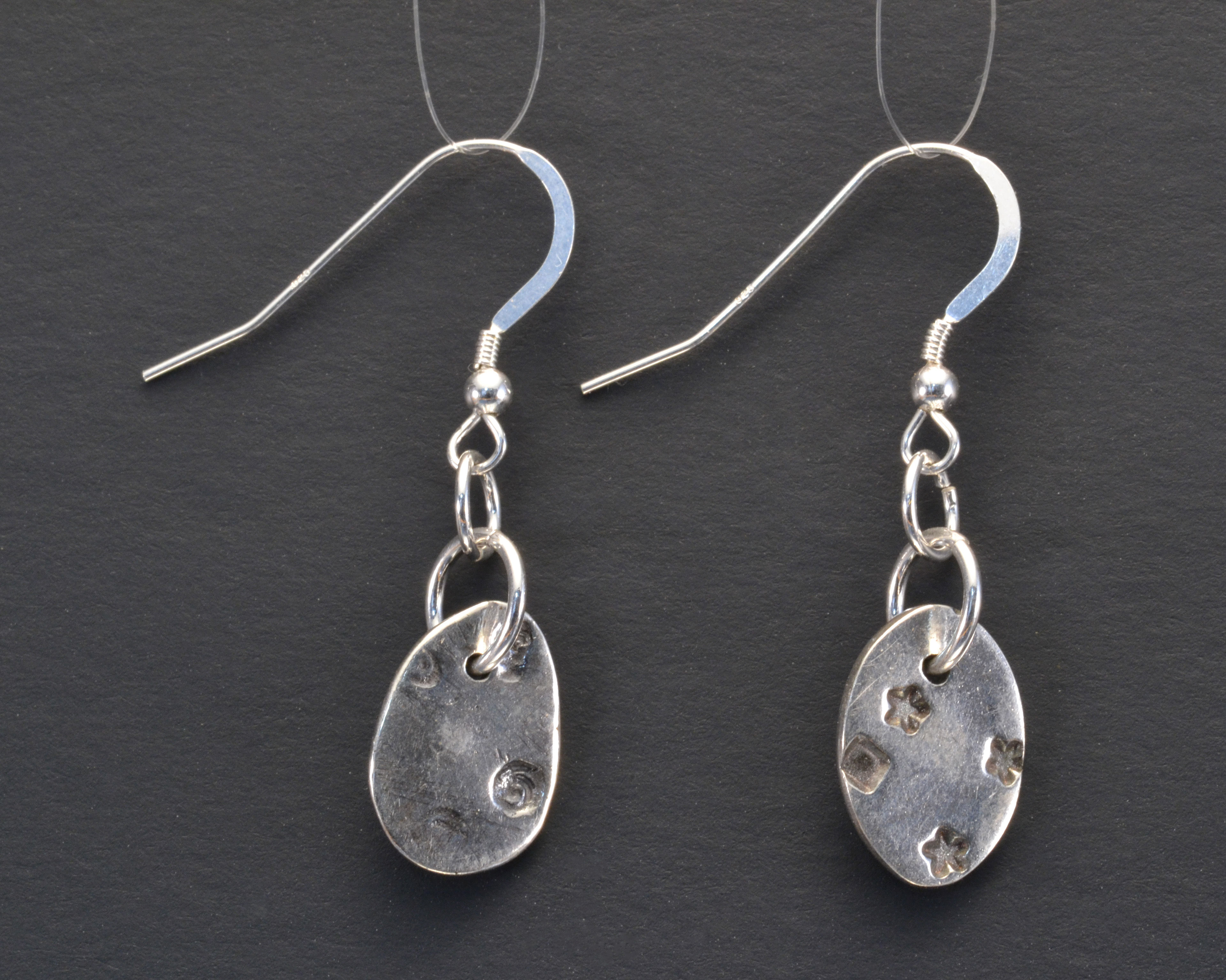 silver clay oval earrings with star, square textures.