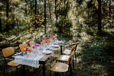 Tischdekoration mit bunten Blumen im Wald 