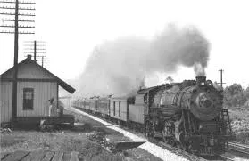 A historical photo of the Franconia Railroad Station in 1941 with a steam locomotive passing by.