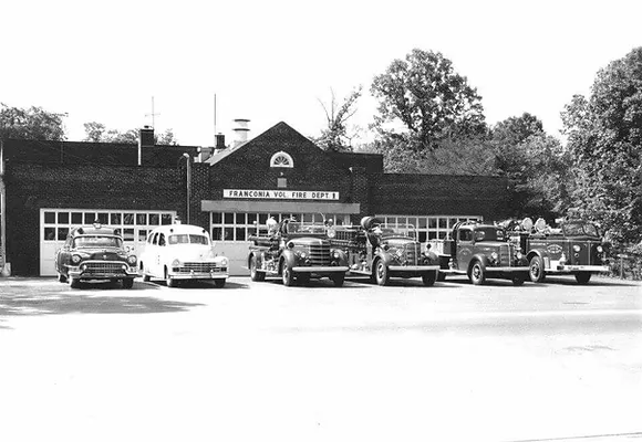 A 1950 image of the Franconia Volunteer Fire Department station as viewed from across Beulah Road with all of the fire engines and ambulance parked in front of the building.