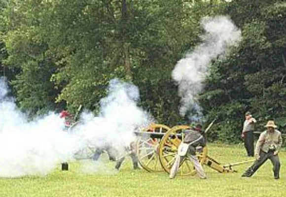 Confederate reenactors fire a cannon at Hazel Grove.