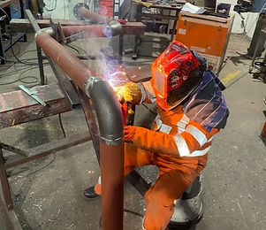 man in orange welding