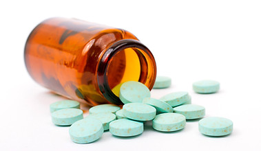 Medicine pills spilling out of brown glass container