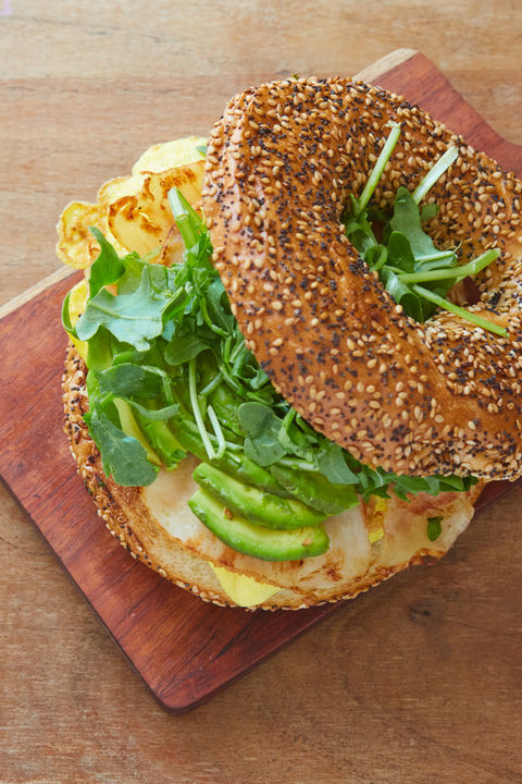 bagel sandwich shot from overhead showing everything bagel, arugula, avocado, smoked turkey and egg