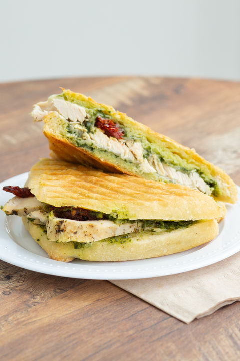 Chicken pesto panini cut in half on a plate