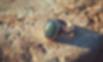 vecteezy_a-green-stone-ring-is-on-a-stone-surface_58293387.jpg