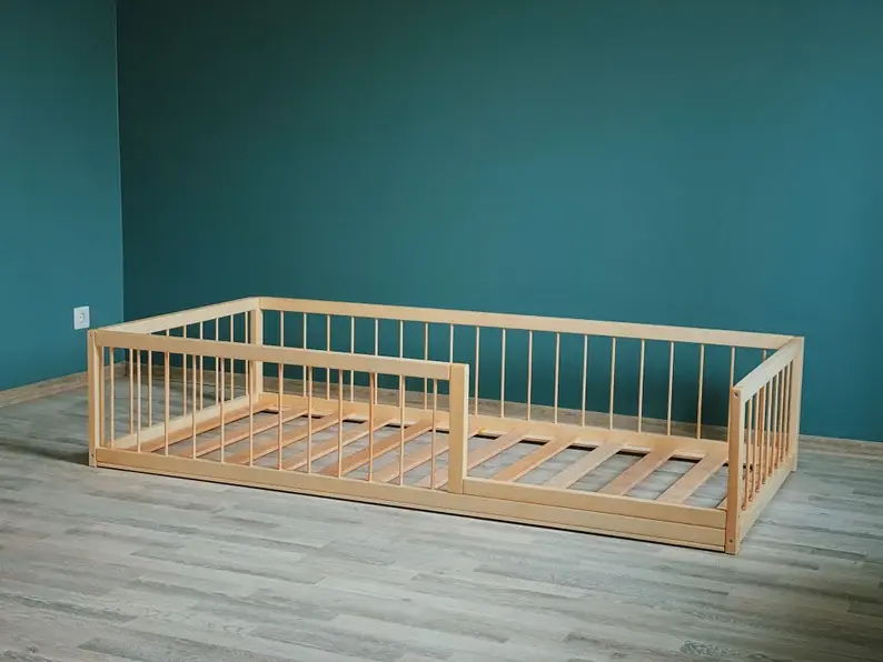 A natural wood floor bed frame for toddlers in a green room.