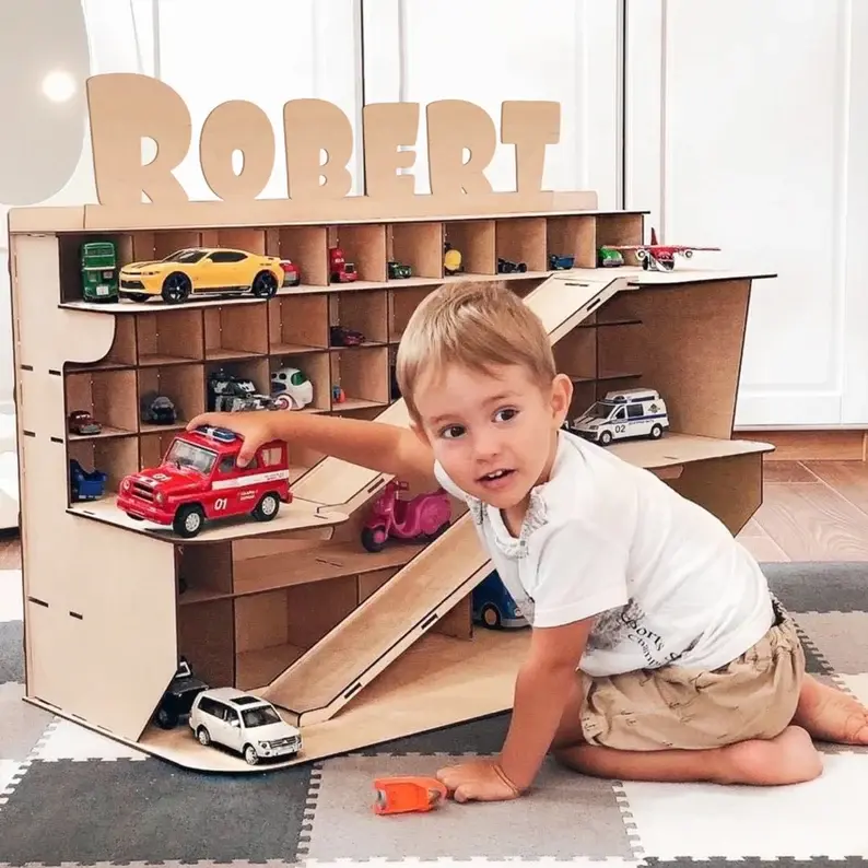 A boy named Robert playing with his toy cars.