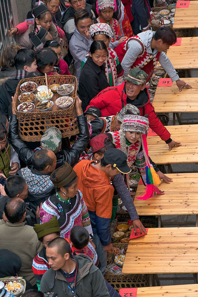 Villagers are preparing food and tables on the street for "Long Table Feast" ritual. Yuanyang, Yunnan province, China.
