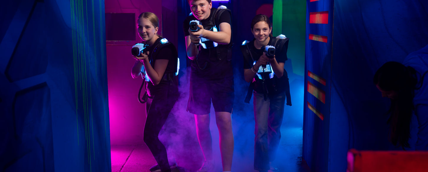 Drei Kinder spielen Lasertag im Innenraum der LaserZone Köln