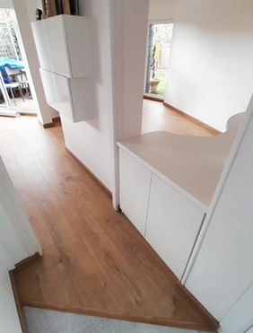 Aménagement sur mesure d’un bureau ouvert sur le salon avec cache-compteur et colonne démontable pour le ballon d’eau chaude, et pose de parquet dans le bureau et le salon avec jonction harmonisée au lino de l’entrée, réalisation par Le Bail Agencement – menuisier, agenceur, ébéniste dans le Morbihan.