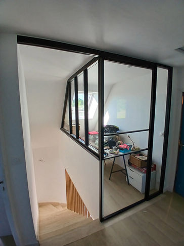 Verrières sur mesure en sous-pente à Ploemeur avec portes coulissantes, conçues, fabriquées et posées par Le Bail Agencement – menuisier, agenceur, ébéniste dans le Morbihan. Séparation fonctionnelle et esthétique entre mezzanine et escalier, avec design adapté aux rampants et fermeture sécurisée.