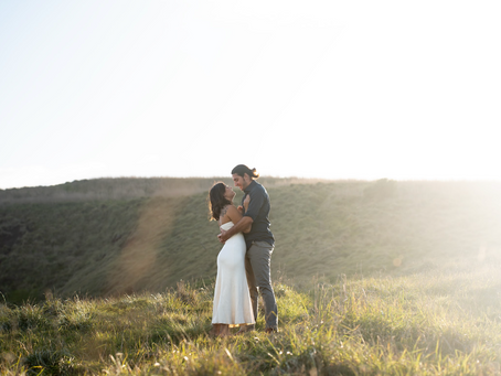 Man and woman in embrace on a hill during golden hour