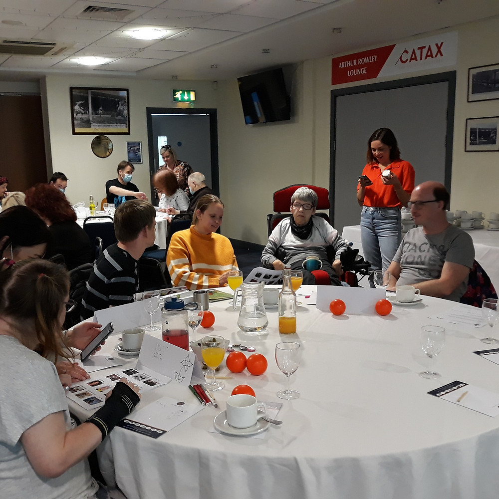 FCHA's Eve with tenants at a table.