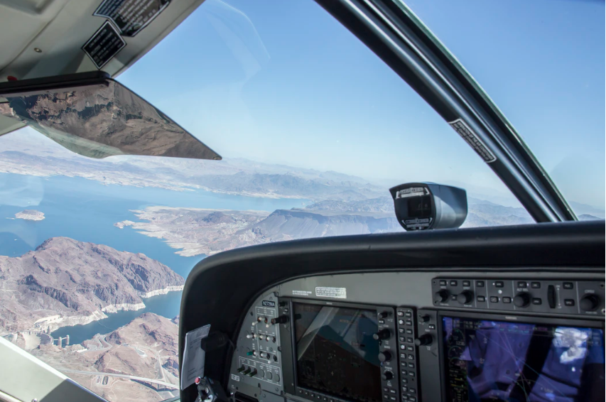 A pilot in the cockpit of a plane near the Swiss Alps