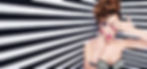 Woman with bold curly updo and dramatic makeup, featuring colorful eye shadow and pink-striped lipstick, posing with one hand covering an eye. Her nails are painted in a mix of pink, black, and striped designs, set against a black-and-white striped background