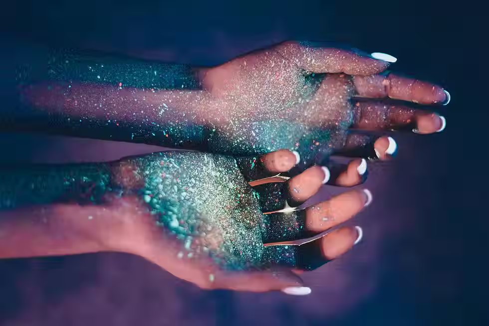 a woman's hands covered in green glitter