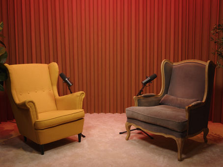 Goldmine Podcast Studio in Hollywood: two guest chairs, boom microphones, draped backdrop, and plants on a video podcast set.