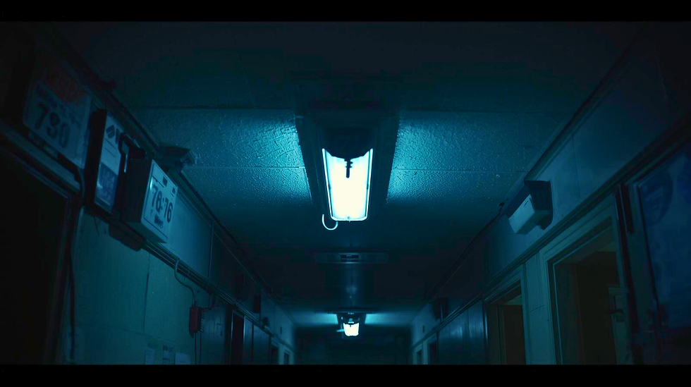 Night dorm corridor under harsh blue fluorescent lights; low ceiling tiles feel close; open doorways line both sides, everything quiet and oppressive.